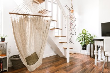 hanging hammock beneath stairs in a room with hardwood