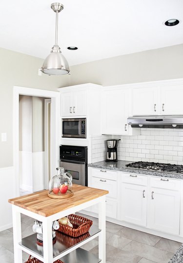 white kitchen with white subway tile and moveable island