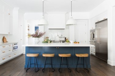 blue and white kitchen with navy blue island and white pendants