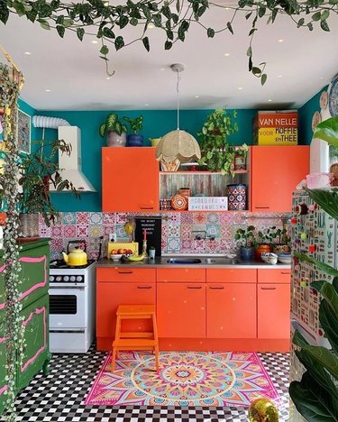orange kitchen color idea with teal walls and patterned floor tile and backsplash tile