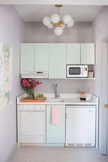 small retro mint green kitchen with white appliances and countertop