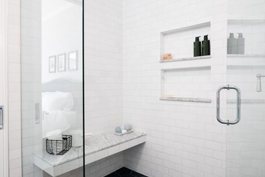 subway tile shower with marble bench