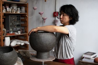 figure working on a ceramic piece in studio space