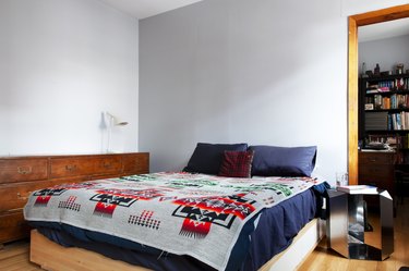 bedroom space with wooden dresser and mirror side table