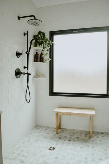 white shower with window and corner bathroom shelving