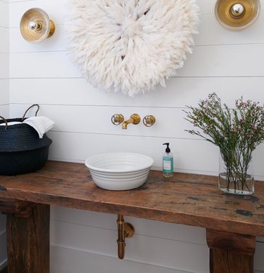 Shiplap and brass fixtures lend a farmhouse vibe to this bath.