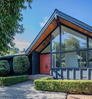 Orange midcentury modern front door with pitched roof and midcentury details