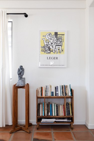 bookshelf, statue, and framed poster