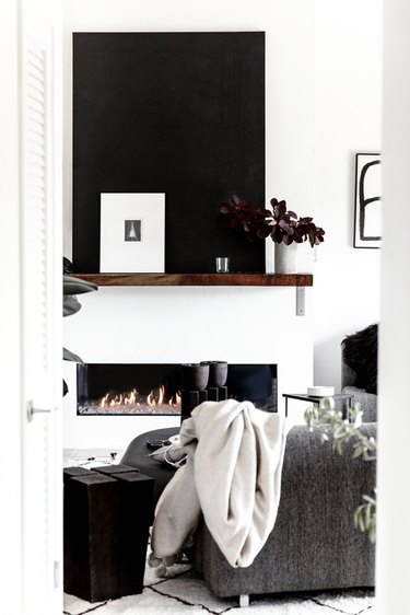 Modern black and white living  room with fireplace and wood mantel