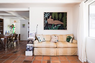 living room space with yellow couch and artwork