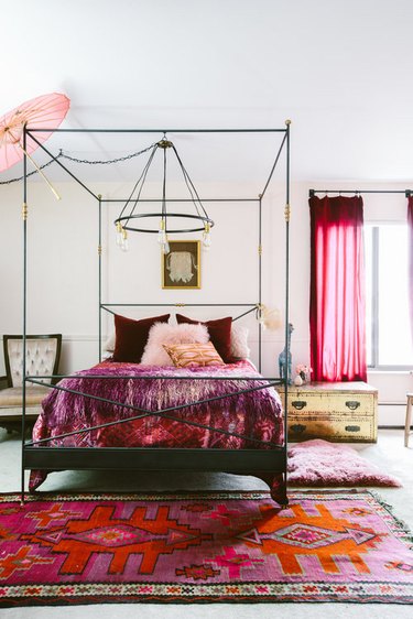 bedroom with pink area rugs and pink drapery and four-poster bed