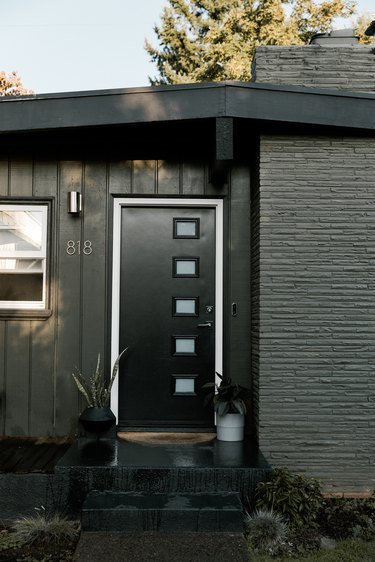 Black midcentury modern front door with matching black exterior