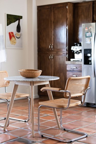 dining room table with two chairs and wood cabinets in the background