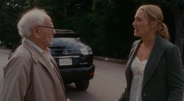 old man and woman talking in front of Lexus, still image from the holiday