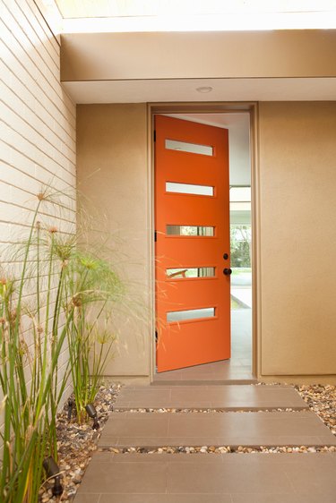 Orange midcentury modern front door with rectangular windows and a modern exterior