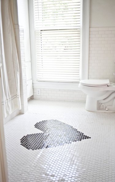 white bathroom with white and black mosaic bathroom floor tile