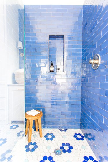 Coastal shower with blue tile walls and white and blue floral floor