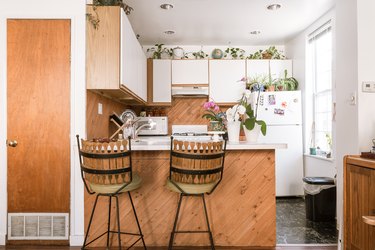 wood kitchen with white cabinet fronts, plants
