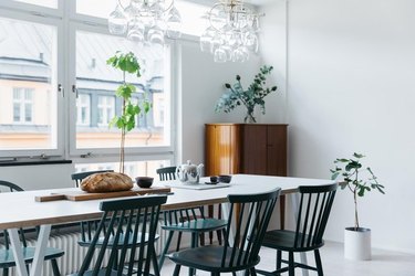 modern dining room with glass pendant lights and green chairs