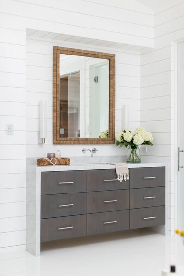 bathroom space with shiplap walls and dark cabinets