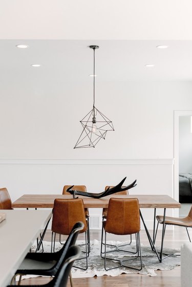 minimalist dining room with leather dining chairs and abstract pendant