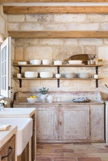 rustic farmhouse kitchen with distressed cabinets and brick floor