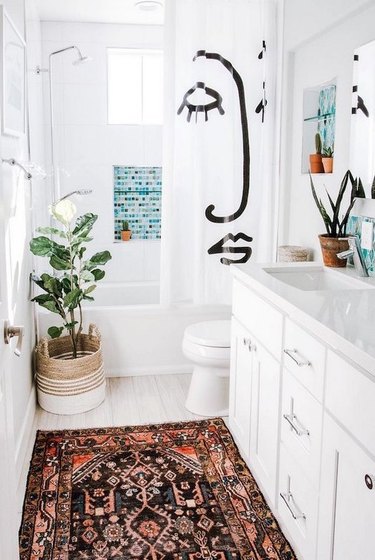 white bathroom with potted plant and area rug