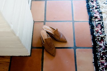 Saltillo tile detail with shoes and area rug