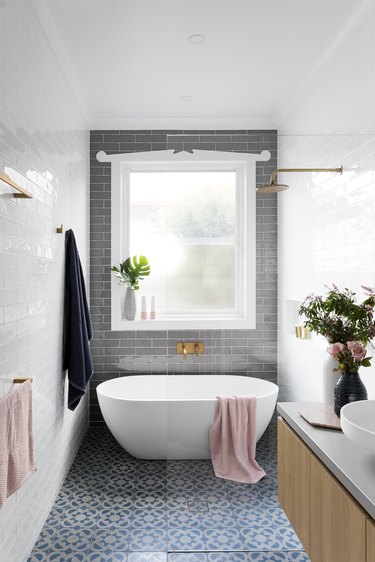 walk-in bathtub shower combination with gray accent wall and patterned tile floor
