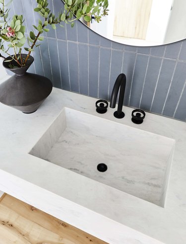 marble sink with blue tiles in the background