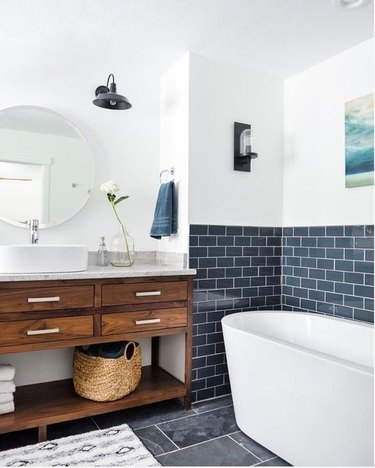 bathroom tub backsplash idea with bluish-gray subway tile behind freestanding tub