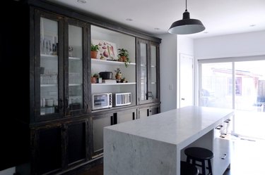 modern kitchen with black distressed cabinets and industrial pendant light