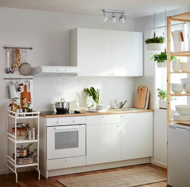 kitchen space with white cabinets and white storage cart