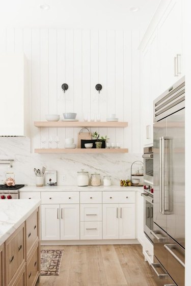 White farmhouse kitchen with shiplap wall and open shelves
