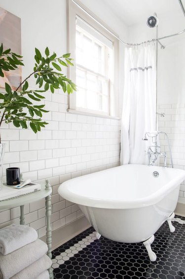 white bathroom with white subway tile walls and black and white hexagon mosaic floor tile