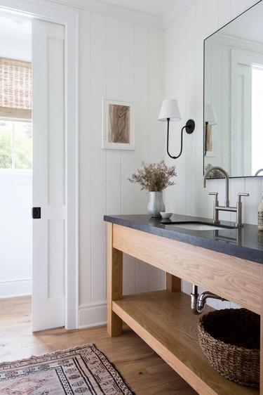 bathroom with wood vanity and black countertop