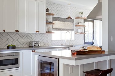 white kitchen with shaker cabinets and herringbone subway tile