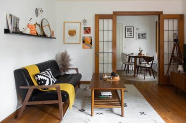 living room with mid century modern leather couch and wood floors