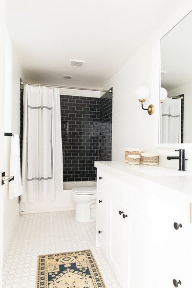 modern shower idea with black subway tile in modern white bathroom