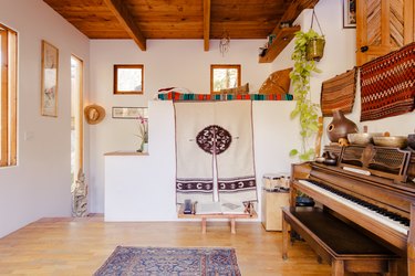 view of a piano and hardwood floors. Southwest design