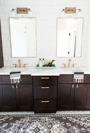 master bathroom with dark wood cabinets and his and hers sinks