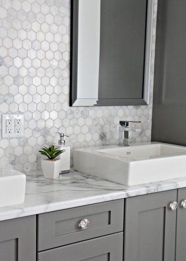 bathroom with gray cabinets and marble laminate countertop