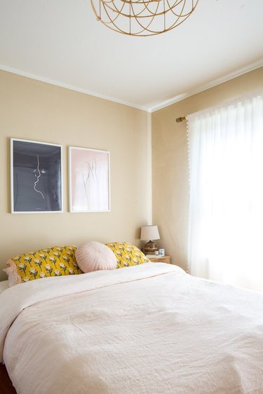 Bedroom with beige walls and pale pink bedding