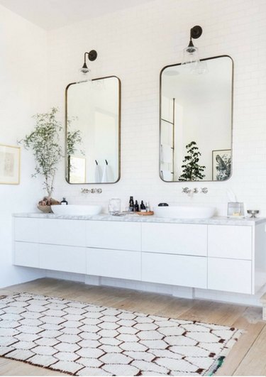 his and hers sinks in master bathroom with wood flooring