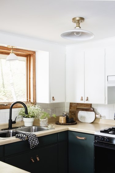 modern kitchen with green and white cabinets and double sink