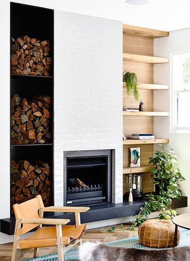 midcentury fireplace with built in shelving and stacked wood