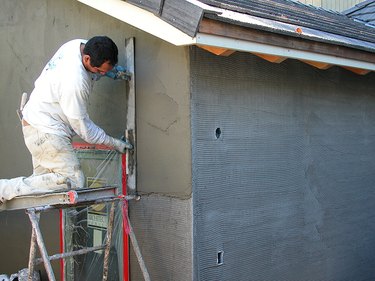 Workman troweling stucco.