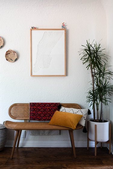 bench with pillows and framed artwork nearby