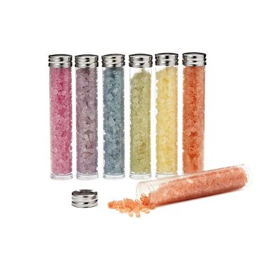 Seven cylinders of bath salts in different colors