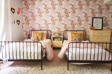 floral wallpaper and black IKEA beds in pink kids bedroom idea